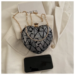 Detail of silver sequined heart evening bag with gold chain and phone for scale