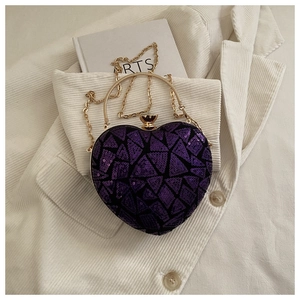 Detailed view of heart-shaped evening bag with purple sequins and gold metal handles
