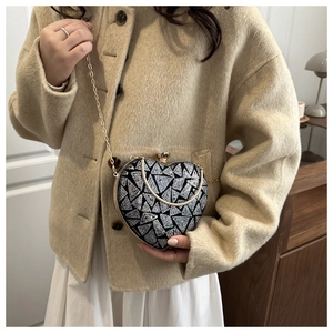 Close-up of heart-shaped sequin evening bag with silver and black geometric pattern
