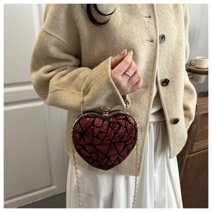 Detail view of heart-shaped sequin evening bag with crystal clasp and golden chain