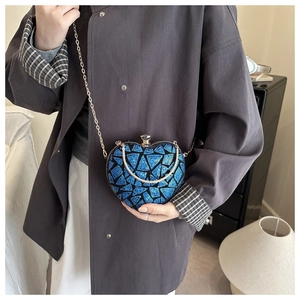 Detail of blue sequined heart clutch bag with gold chain strap and crystal clasp knob
