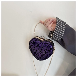 Macro detail of purple sequin heart-shaped evening bag with gold handle and crystal clasp