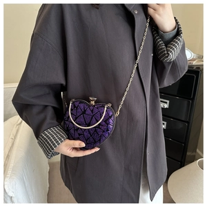 Detail view of heart-shaped evening bag featuring purple sequins and a gold chain strap