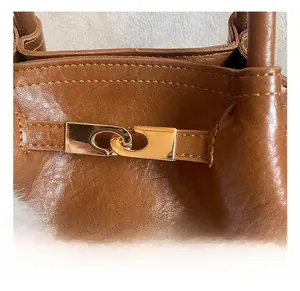 Gros plan sur le cuir plissé marron avec boucle métallique dorée raffinée du sac à main
