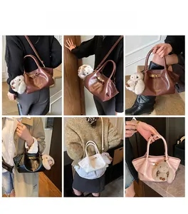 Détail du sac à main en cuir avec fermoir rotatif en métal et breloque lapin en peluche