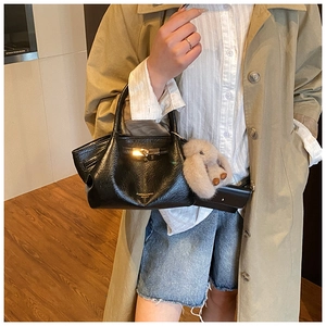 Détail du sac dumpling noir plissé avec fermoir doré et breloque lapin gris