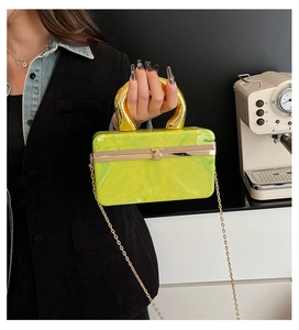 Macro shot of green marble acrylic clutch with chunky gold handle and chain strap