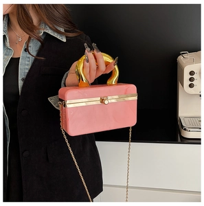 Detail of pink marble box clutch with gold horseshoe handle and chain strap