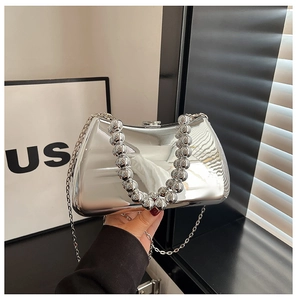 Detail view of silver acrylic evening bag with beaded handle and metallic mirror finish