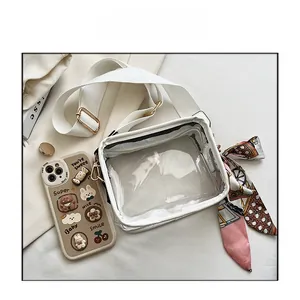 Détail d'un sac en gelée transparent avec foulard en soie imprimé et bandoulière blanche