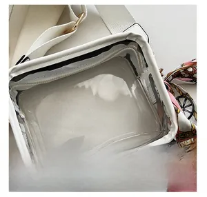 Dettaglio della borsa a tracolla in PVC trasparente con bordo bianco e foulard decorativo