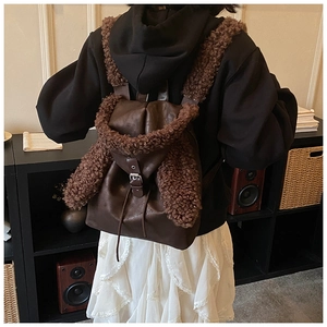 Detail eines dunkelbraunen Lederrucksacks mit Teddyfleece-Besatz und Kordelzug