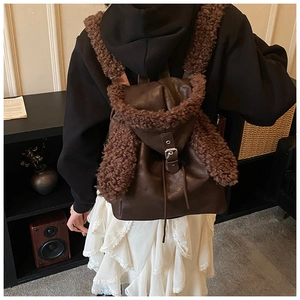 Close-up of brown plush bunny ear backpack with faux fur trim and metal buckle detail