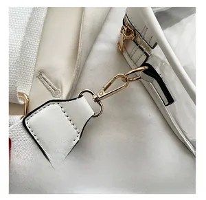 Détails des ferrures dorées polies avec fermoir mousqueton et zip sur sac blanc