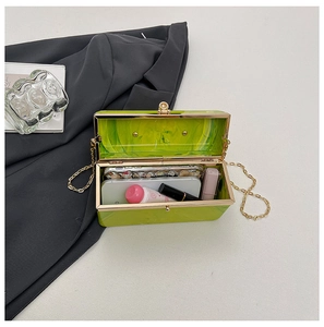 Detail of green marble acrylic clutch bag showing interior space for phone and makeup