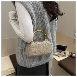 Close-up of champagne gold rhinestone evening bag with elegant bamboo-style handle