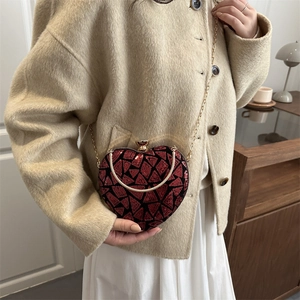 Sparkly heart-shaped sequin dinner bag with red and black geometric patterns and gold chain