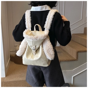 Detailed view of the fuzzy rabbit ear backpack in cream faux leather with plush trim