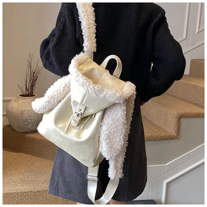 Detail of plush beige backpack showing the fuzzy texture and silver buckle strap