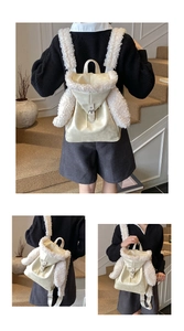 Detail of plush faux shearling trim and adjustable metal buckle on cream faux leather backpack