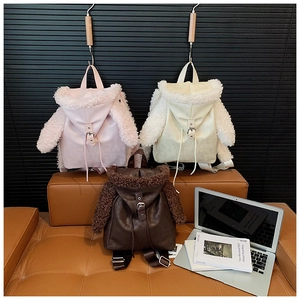 Detail of plush lamb wool and leather backpacks in pink, cream, and brown tones