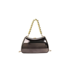 Detail of mirrored electroplated acrylic evening bag with gold bead handle and chain strap