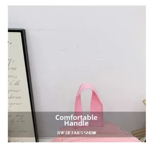 Detail showing the comfortable pink nylon top handle with reinforced stitching on the backpack