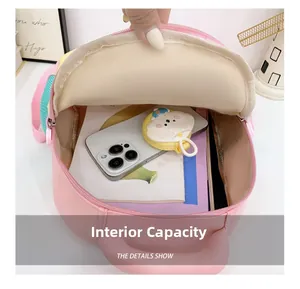 Internal capacity of pink macaron schoolbag showing space for a smartphone and booklets