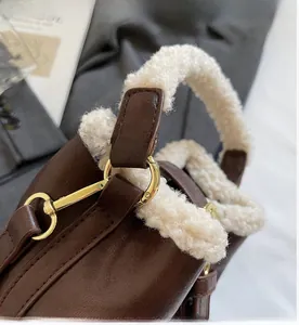 Détail du sac en cuir marron avec poignée en fausse fourrure blanche et anneaux dorés
