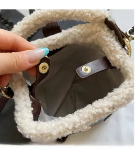 Détail du sac d'hiver en peluche avec fermoir doré et doublure à motifs vagues