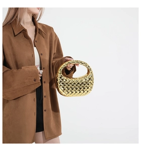Golden woven hobo bag shown on a brown coat model with metallic mirror finish