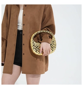 Close-up of gold woven hobo bag with high-gloss metallic finish and leather craftsmanship