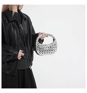 Detail of silver metallic woven acrylic hobo bag with reflective mirror finish texture