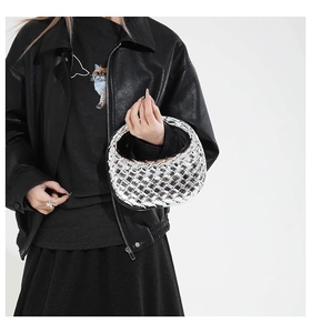 Detail view of silver mirror woven crescent handbag with metallic reflective texture