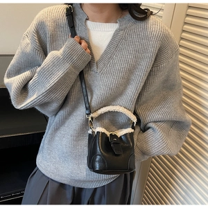 Détail du mini sac seau montrant la bordure en laine d'agneau et le cuir grainé litchi