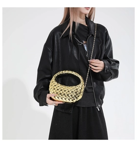 Borsa hobo dorata intrecciata con finitura metallica e sottile catena su modella