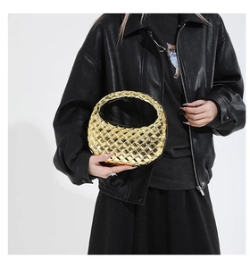 Detail of metallic gold acrylic half-moon evening bag with quilted woven pattern