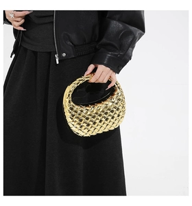 Detail of gold acrylic woven evening bag with hobo style and half moon handle