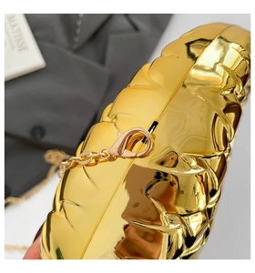 Detail of golden quilted semi-circle evening clutch with detachable chain strap and lobster clasp