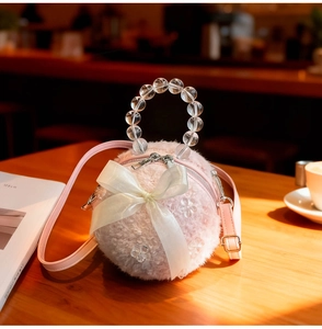 Detail of pink plush round bag with silk bow, flower decor and clear beaded handle