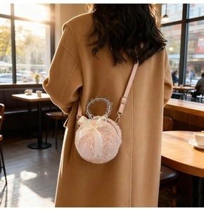 Close-up of pink plush round crossbody bag featuring satin bow and crystal beaded handle