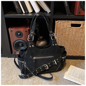 Close-up of black rivet motorcycle bucket bag with silver zippers and multi-pocket design