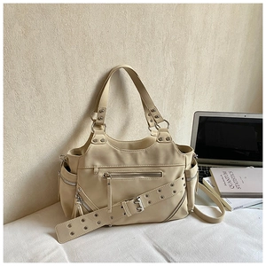 Detail of cream studded biker bucket bag with silver hardware on white fabric