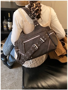 Detail of dark brown punk rivet bucket bag with silver hardware and retro faux leather