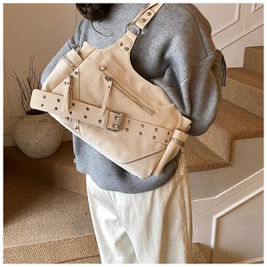 Detail of cream punk tote bag featuring silver zippers and metallic eyelet strap