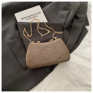 Macro detail of champagne evening clutch featuring radiant glitter texture and gold chain