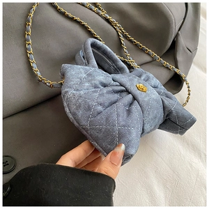 Détail du sac noeud en denim matelassé bleu avec boucle fleurie dorée et chaîne