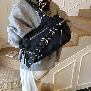 Y2K punk style black studded bucket bag with metallic grommets and wide shoulder strap