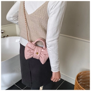 Sac nœud en cuir rose matelassé avec fermoir camélia doré et bandoulière chaîne