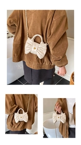 Détail d'un sac blanc matelassé avec design nœud et fermoir métallique en fleur dorée